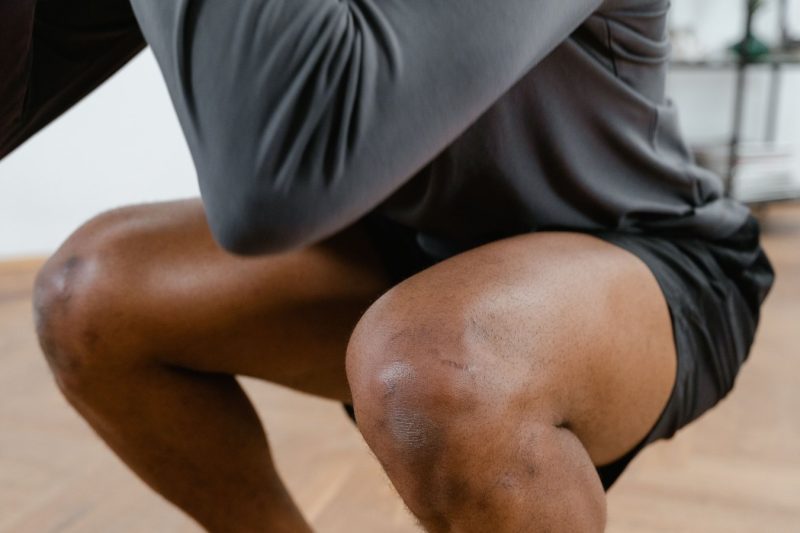 Physical therapist guiding an athlete through a controlled ACL rehabilitation strength exercise