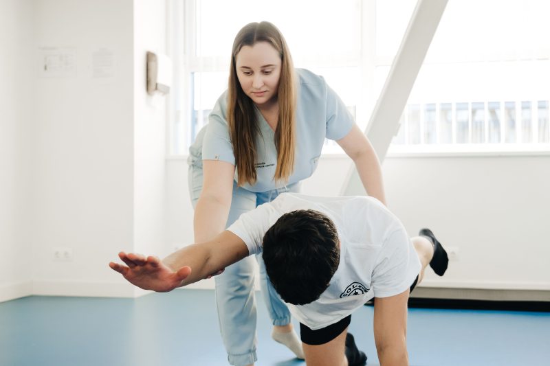Physical therapist guiding a patient through a balance and mobility exercise during rehabilitation.